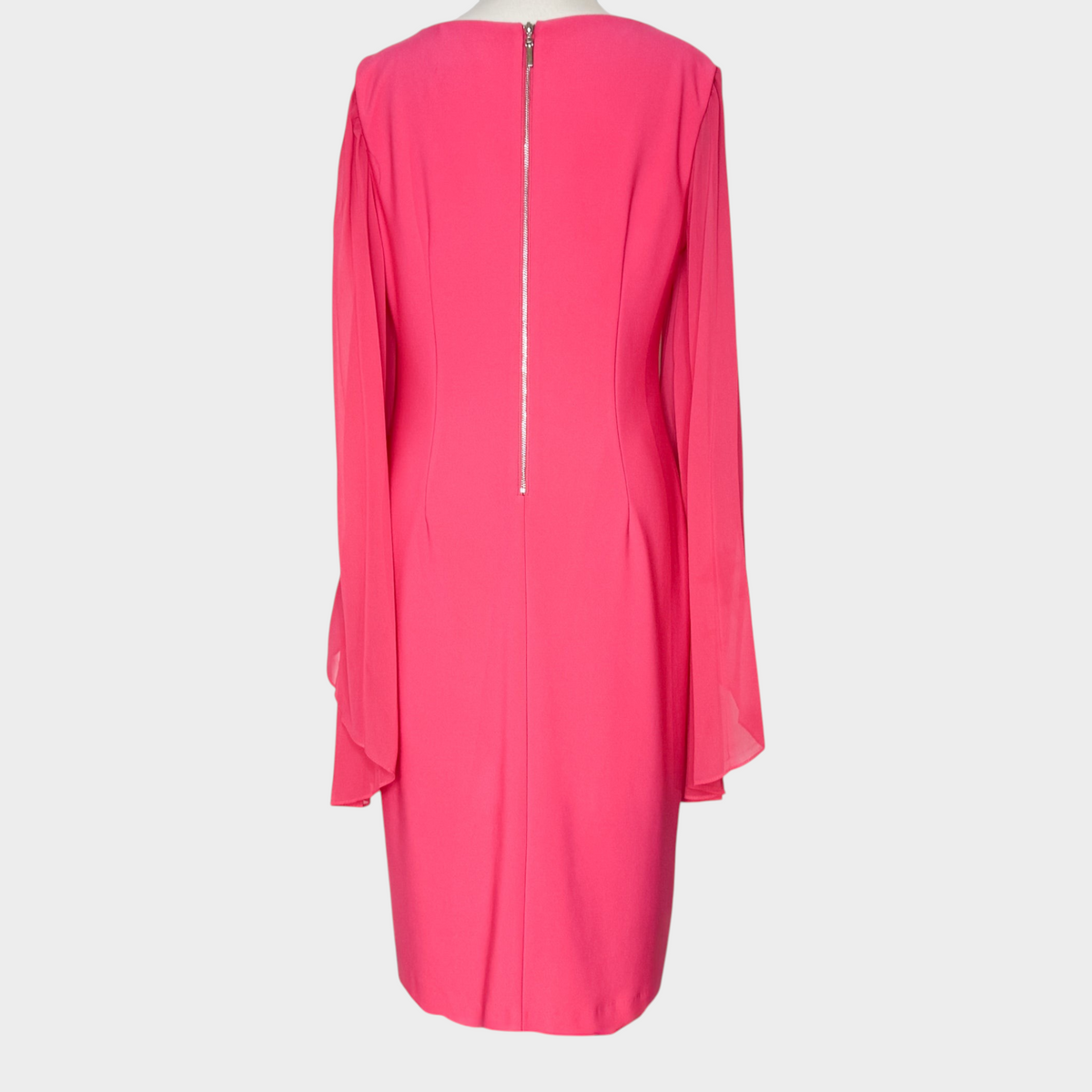 Back view of a bright pink Joseph Ribkoff dress with sheer bell sleeves and a full-length back zipper from Studio61 Preloved Boutique Sydney.